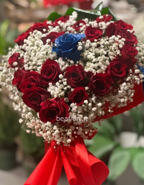 Cuore di rose rosse con al centro una rosa blu